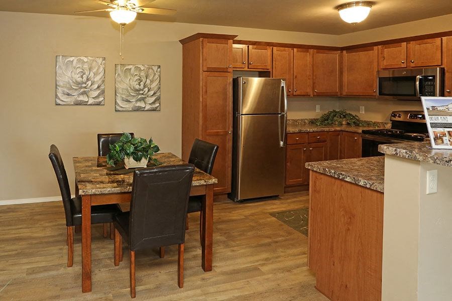 a kitchen with stainless steel appliances and a table and chairs
