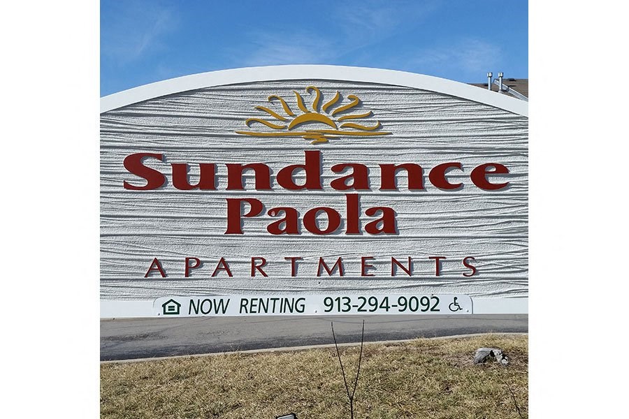 a sign for the sundance palais apartments on the side of a beach