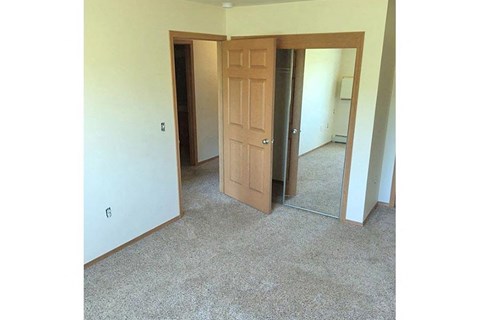 an empty room with a door and a mirror