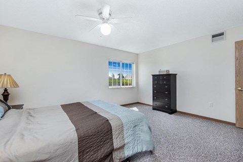 a bedroom with a bed and a ceiling fan
