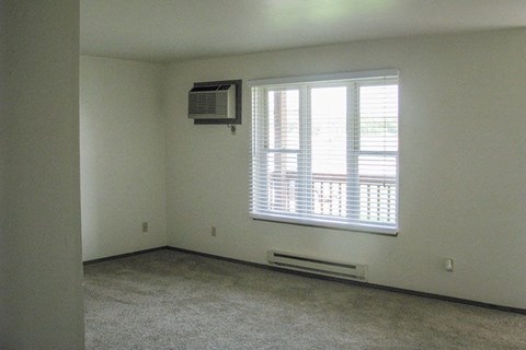 an empty room with a window and a air conditioner