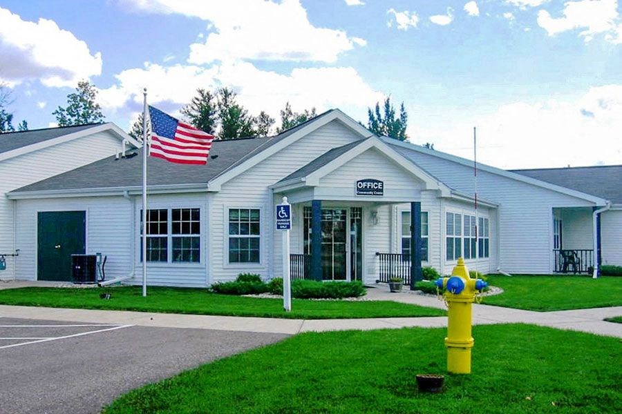 a white building with a yellow fire hydrant in front of it