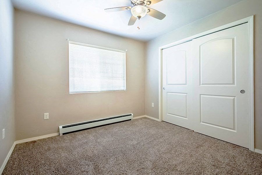 an empty room with a ceiling fan and a white door