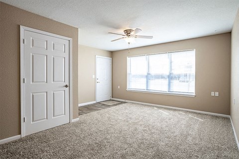 an empty room with a ceiling fan and a window