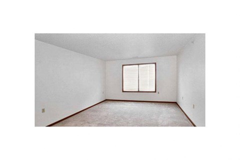 A room with a window and carpeted floor.