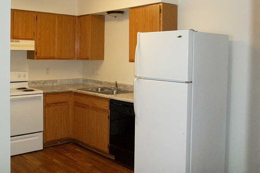 a kitchen with a white refrigerator and a sink