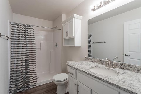 A bathroom with a toilet, sink, and shower.