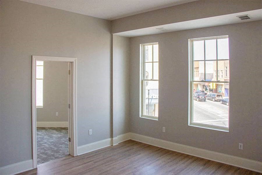 an empty living room with a door and a window