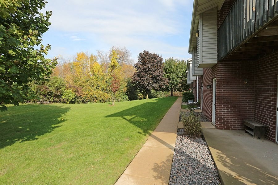 A well-kept lawn leads to a brick house.