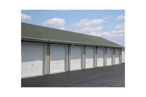A building with a grey roof and white garage doors.