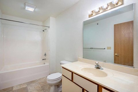 A bathroom with a toilet, sink, and bathtub.