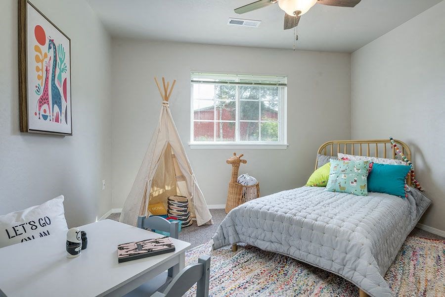 a bedroom with a bed and a desk and a tent