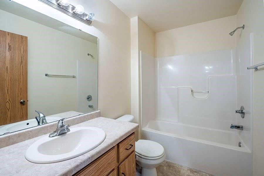 A bathroom with a sink, toilet, and bathtub.