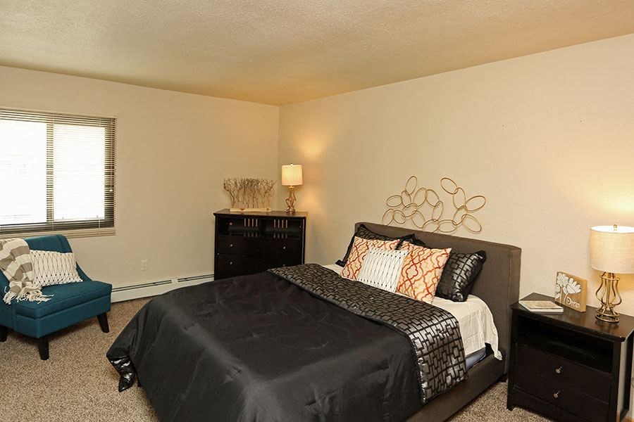 a bedroom with a bed and a chair