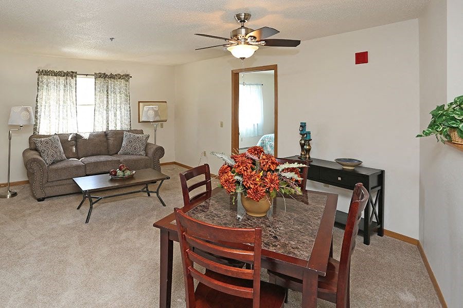 a living room and dining room with a table and chairs