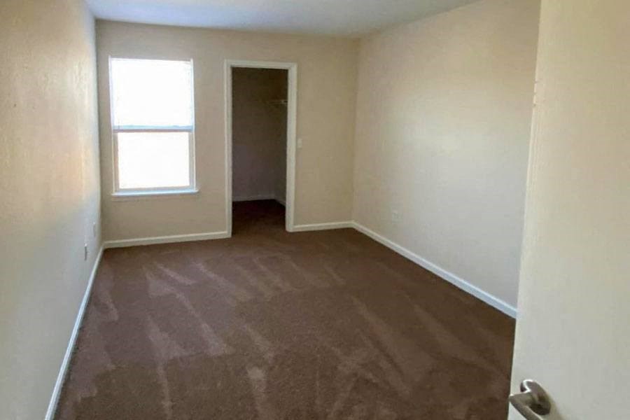 an empty room with a window and a door