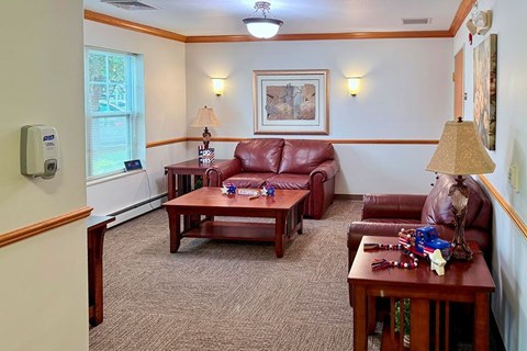 A living room with a red couch and a brown coffee table.