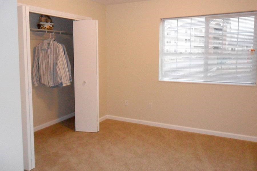 an empty bedroom with a closet and a window