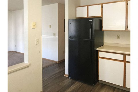 a kitchen with a black refrigerator and white cabinets
