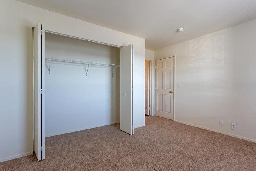an empty bedroom with a closet and a door