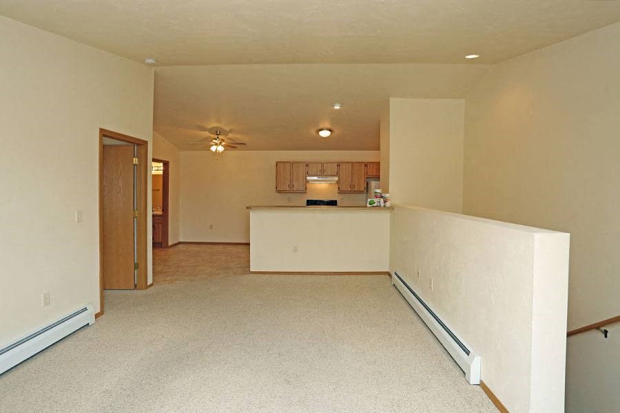 an empty living room and kitchen with a white floor