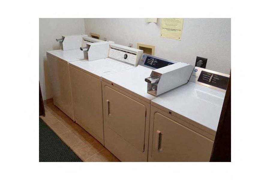 a row of washing machines and cabinets in a room