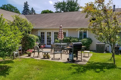 A backyard with a table and chairs and a mailbox.
