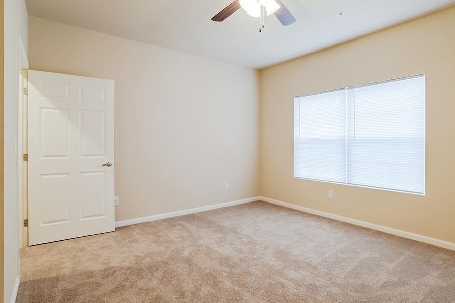 an empty room with a white door and a window