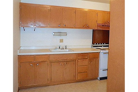 an empty kitchen with wooden cabinets and a sink