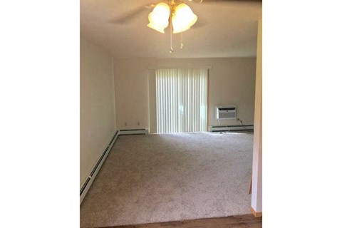 an empty living room with a ceiling fan