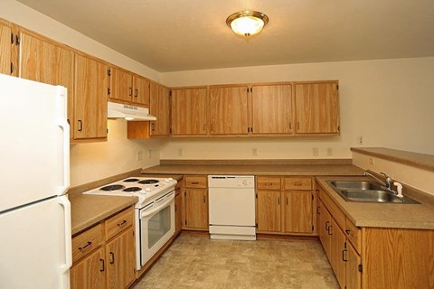 a kitchen with wooden cabinets and a white stove and refrigerator
