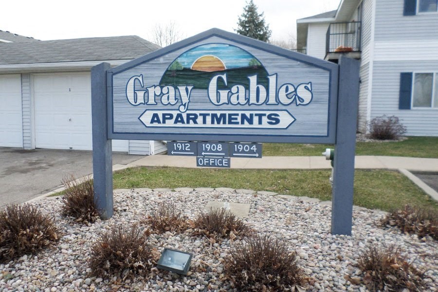 a sign for gray gables apartments in front of a house