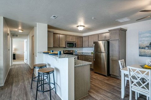a kitchen with a bar and a stainless steel refrigerator