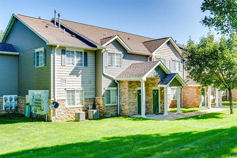a row of houses with green grass and trees