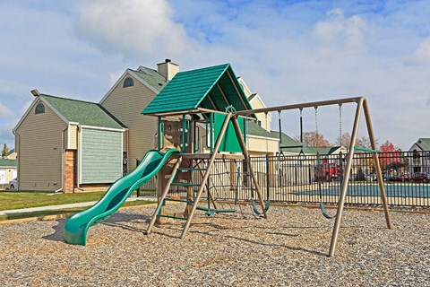a swing set with a slide in a playground