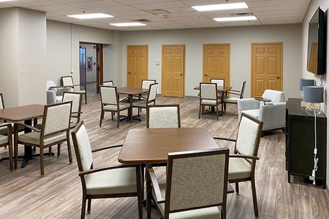 A conference room with a long table surrounded by chairs.
