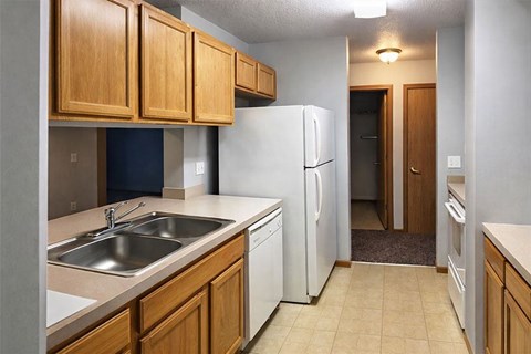 A kitchen with a white refrigerator and wooden cabinets.