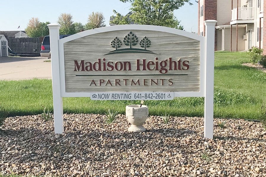 a sign heights apartments in front of a yard