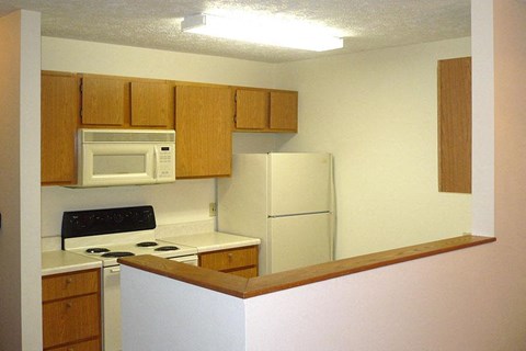 a kitchen with white appliances and wooden cabinets
