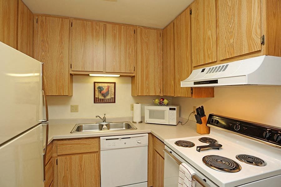 a kitchen with white appliances and wooden cabinets