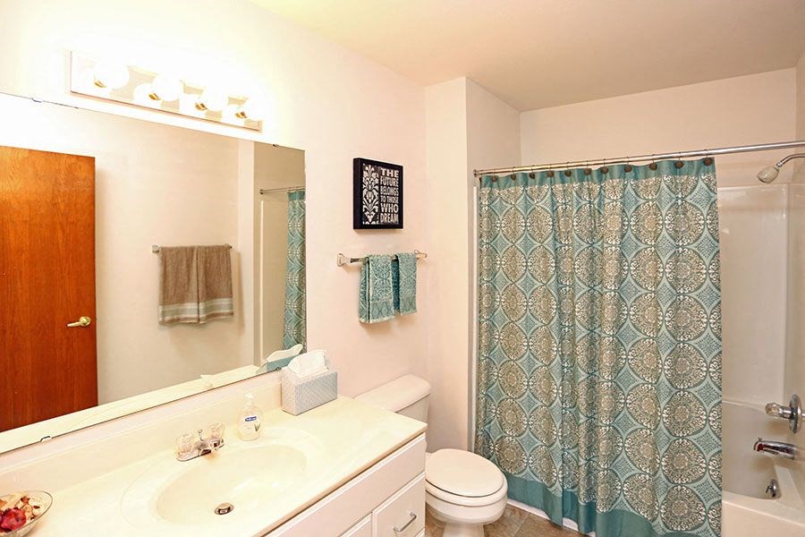 a bathroom with a toilet and a sink and a shower