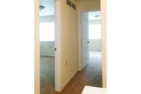an empty living room with a door to a bedroom