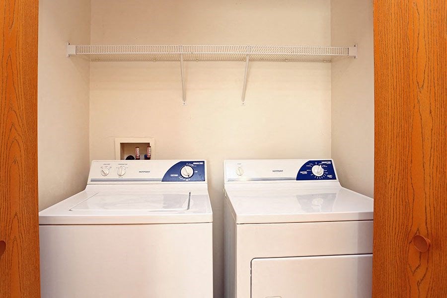 two white washers and dryers in a laundry room