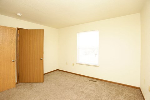 an empty room with a door and a window