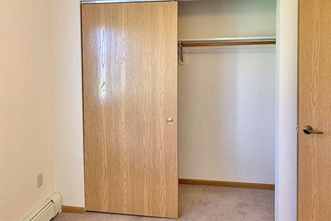 an empty closet with a sliding door in a room