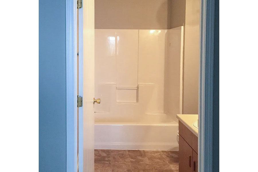 A bathroom with a white tub and a door.