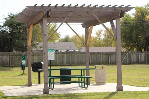 a picnic shelter with a bench in a park