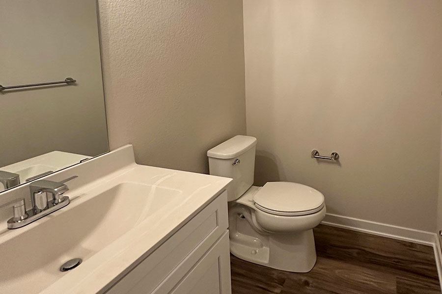 A white toilet sits next to a sink in a bathroom.