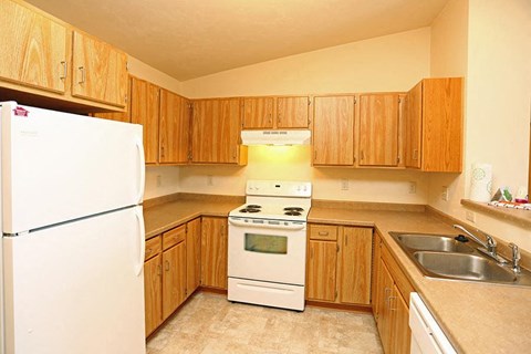 a kitchen with a stove refrigerator and sink