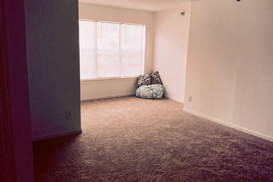 an empty room with a chair and a window